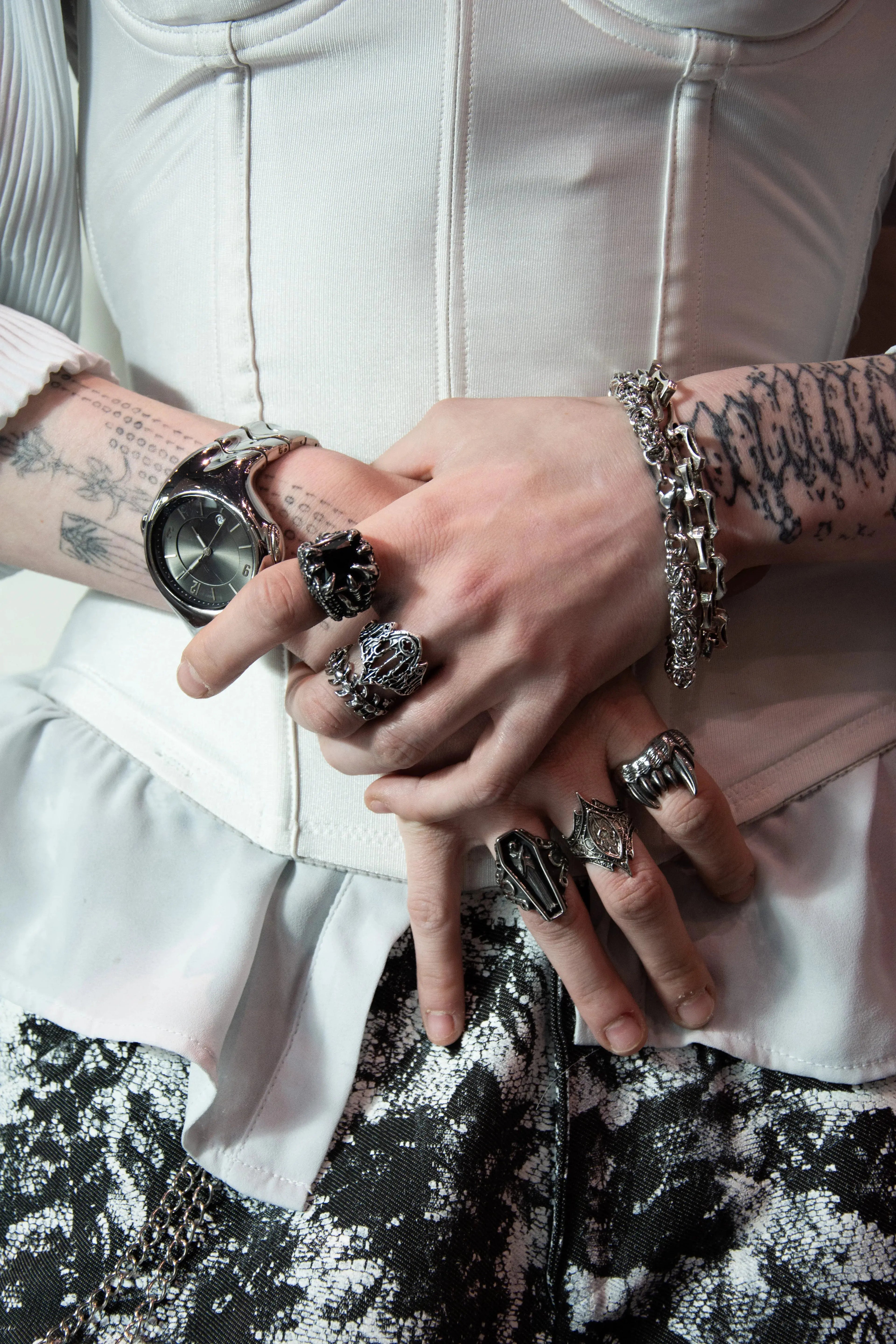 Bracelet chaîne minimaliste en acier inoxydable porté avec d’autres bijoux alternatifs