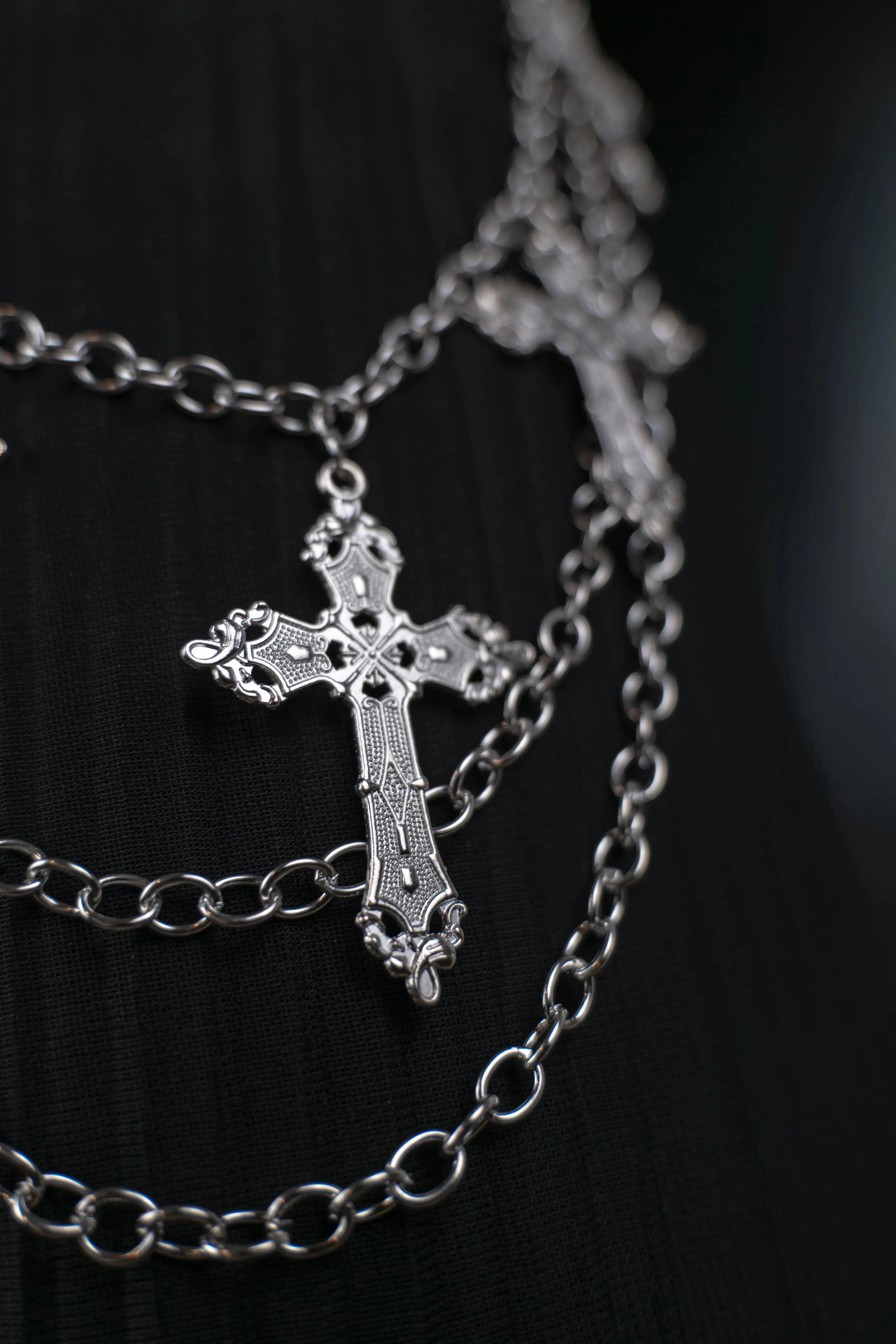 Chaîne de pantalon gothique en acier inoxydable avec pendentifs croix portée sur pantalon noir, style punk rock alternatif