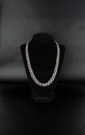 Chaine à maillon ouvert en acier inoxydable posée sur un présentoir bijoux en velours noir.