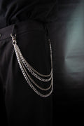 Chaines de pantalons en acier inoxydable accroché à un trouser noir sur fond noir.
