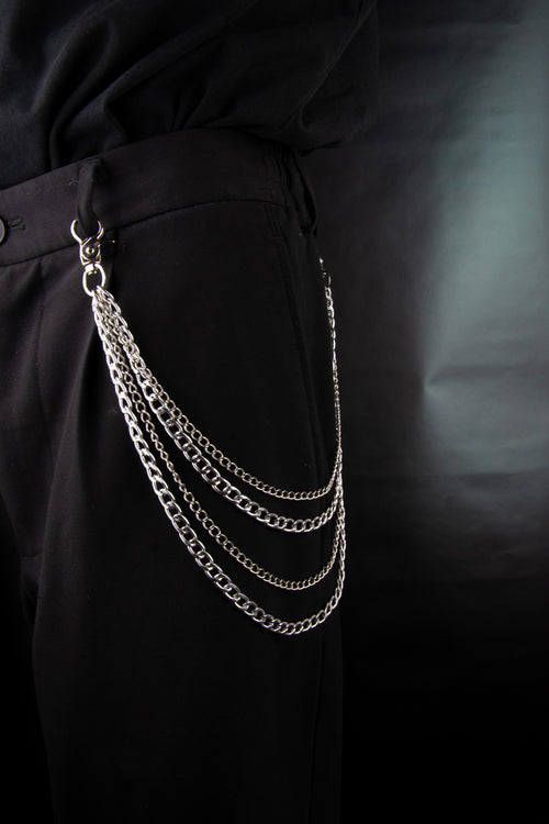 Chaines de pantalons en acier inoxydable accroché à un trouser noir sur fond noir.
