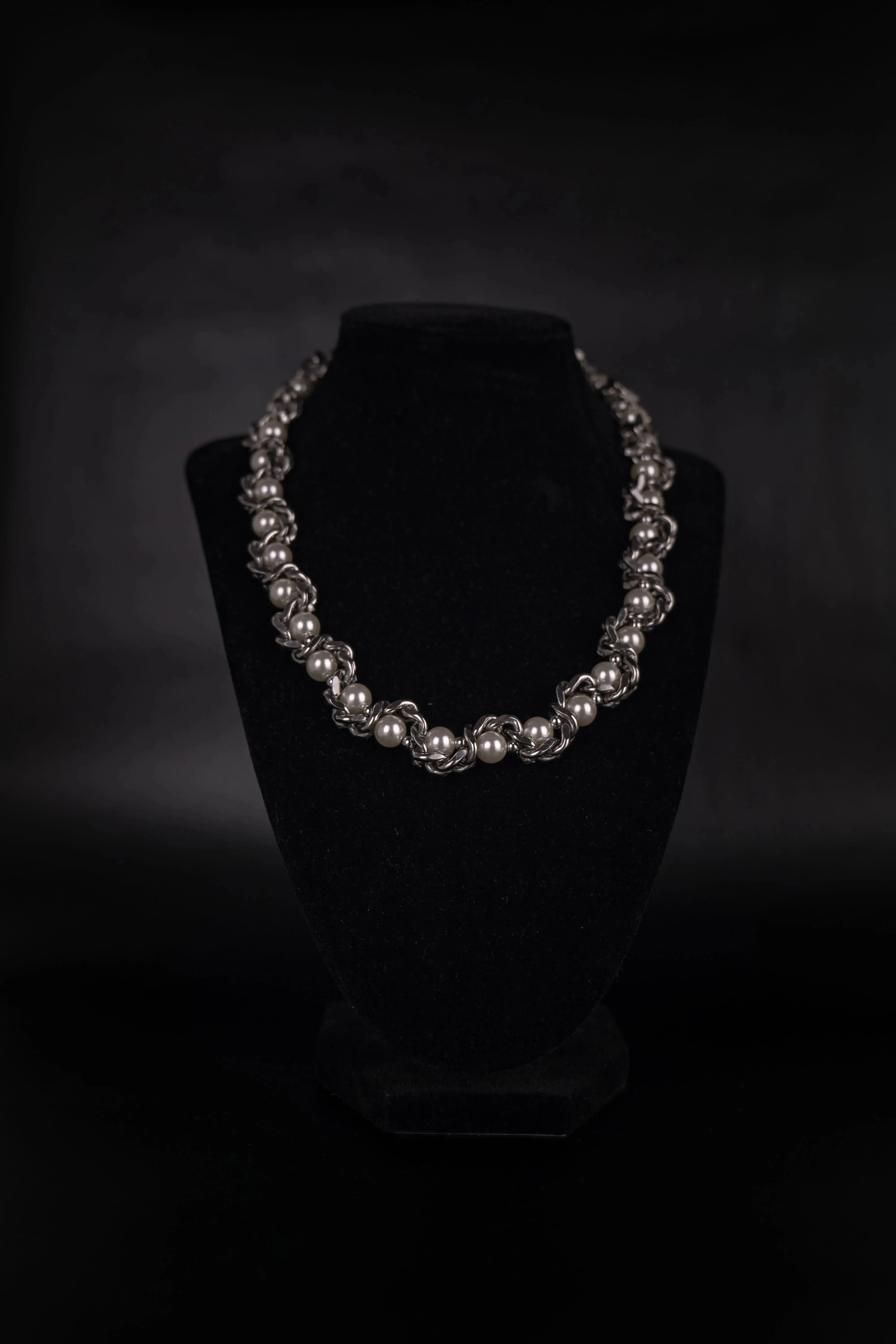 Un collier fais d'une chaine en acier inoxydable entrelacée de perles blanc nacré mélangeant effet brut du métal et raffiné des perles. Collier mixte.