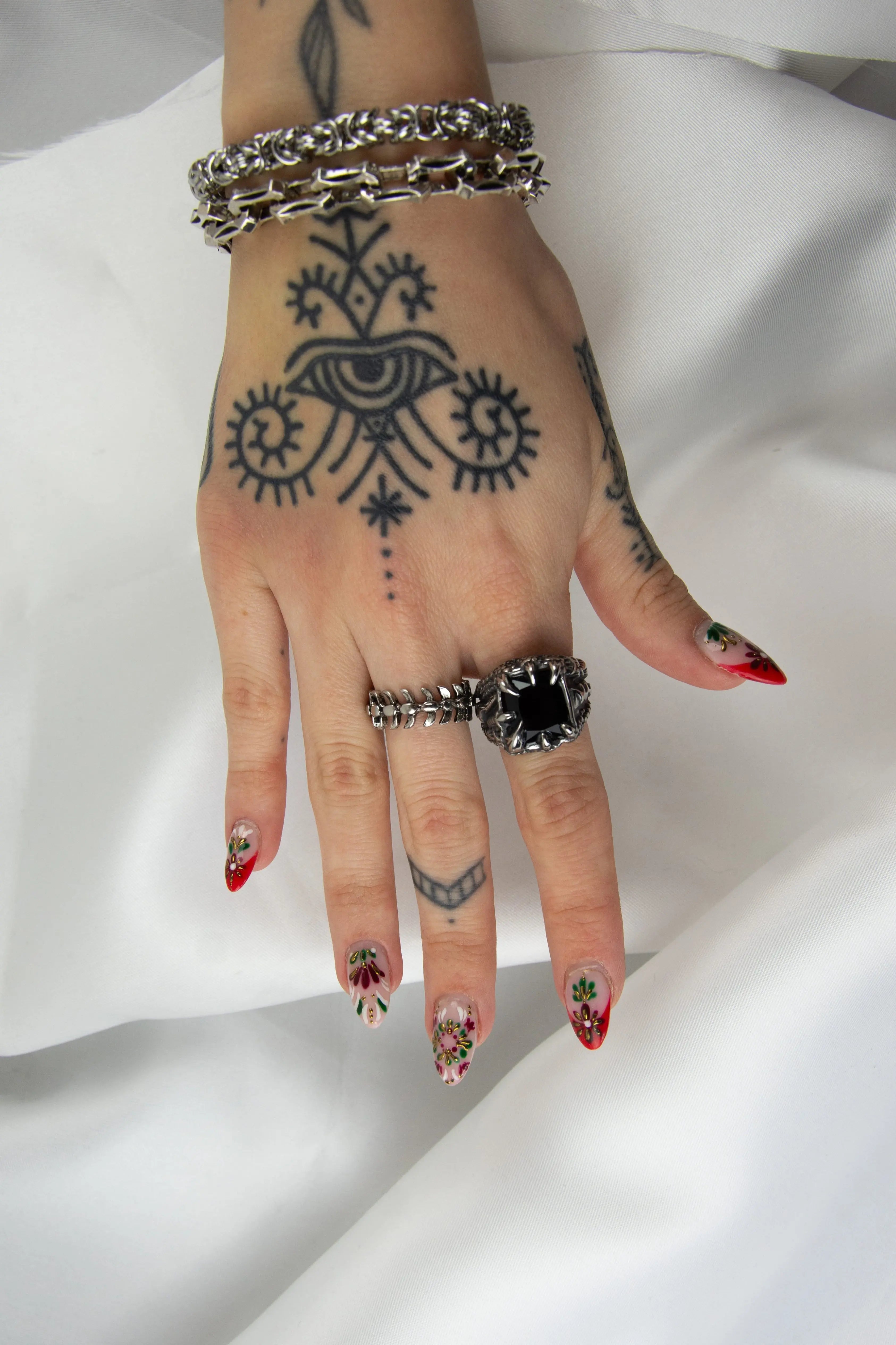 Bague chevalière avec pierre noir tenu entre des griffes acérée.