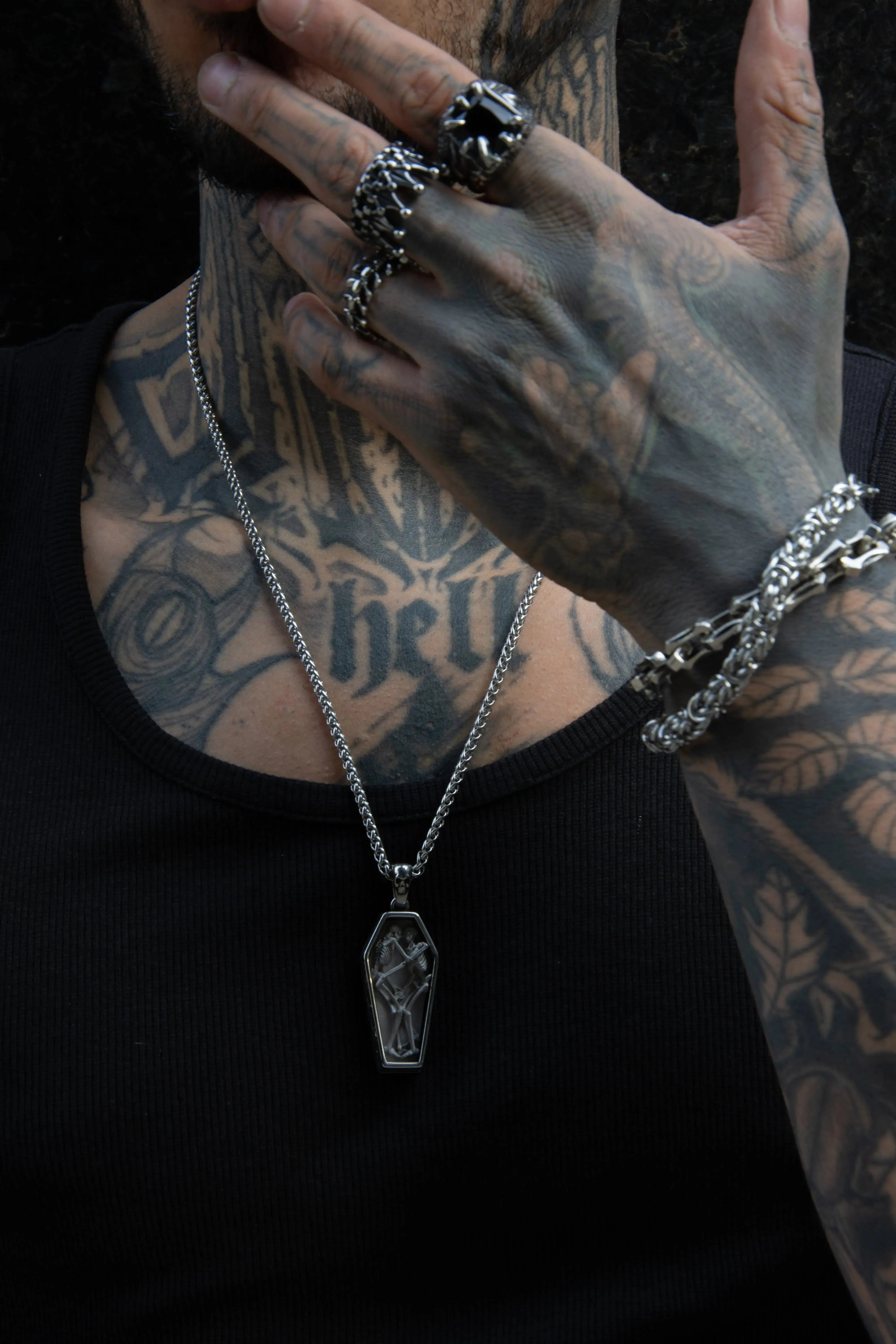 homme tatoué portant des bijoux alternatif et rock, gothique, pendentif deux squelettes amoureux s'enlaçant dans un cercueil pour toujours